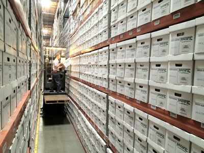 Warehouse shelves full of file cardboard boxes.