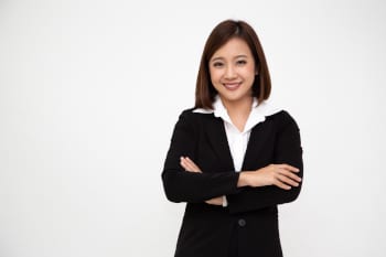 Business person with crossed arms standing against a white background.