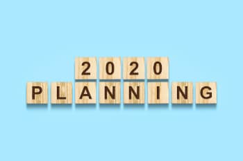 The words "2020 Planning" on wooden letter blocks against a blue background.