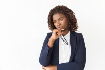 A business person thinking while holding glasses up near face.