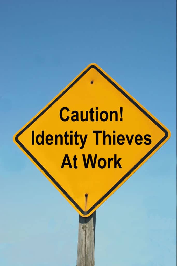 A yellow Warning Sign that reads "Caution! Identity Thieves At Work!"