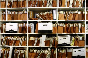 Office shelves full of disorganized files and boxes