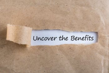 Rough craft paper being torn in the middle revealing the words "Uncover the Benefits"