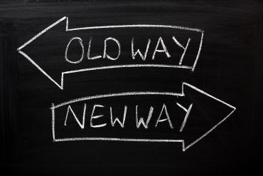 Old Way, New Way written on a blackboard with arrows pointing in the direction of the past and the future.